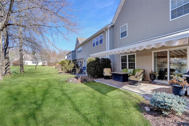 back of house featuring a patio area, a lawn, and a fire pit