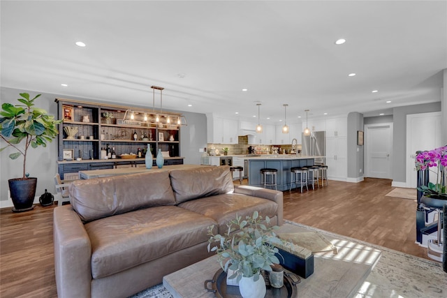 living room with recessed lighting, baseboards, and wood finished floors