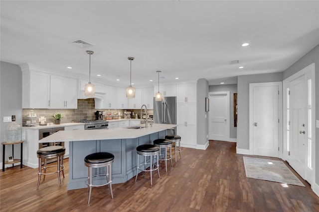 kitchen with white cabinetry, range, visible vents, and a sink