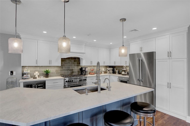 kitchen featuring visible vents, tasteful backsplash, high quality appliances, and white cabinetry