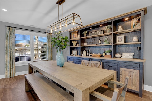 dining room featuring wood finished floors and baseboards