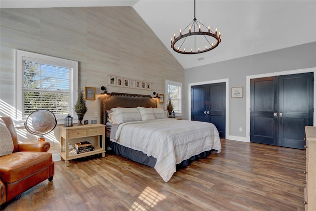 bedroom featuring multiple windows, high vaulted ceiling, and wood finished floors