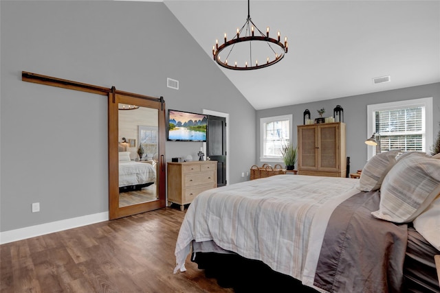 bedroom featuring a barn door, high vaulted ceiling, visible vents, and wood finished floors