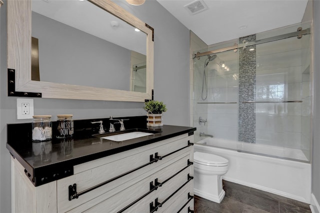 full bath with visible vents, enclosed tub / shower combo, toilet, and vanity