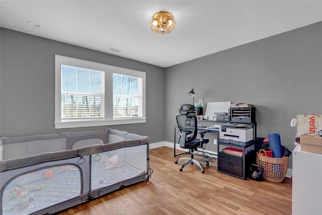 office space featuring visible vents, baseboards, and wood finished floors