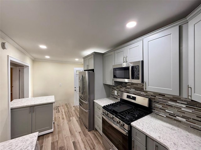 kitchen featuring stainless steel appliances, gray cabinetry, decorative backsplash, and light wood finished floors