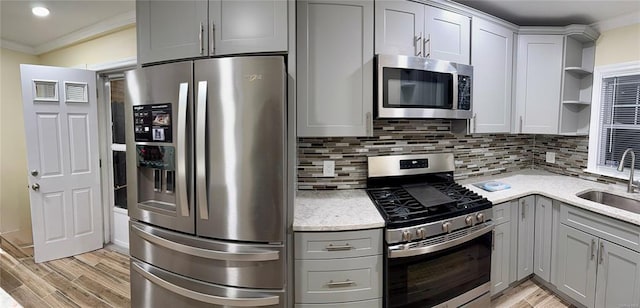 kitchen with tasteful backsplash, gray cabinets, stainless steel appliances, and crown molding