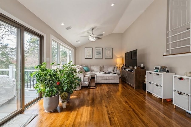 living area with dark wood-type flooring, a ceiling fan, visible vents, and lofted ceiling