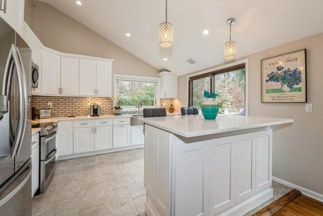 kitchen with stainless steel appliances, white cabinetry, and light countertops