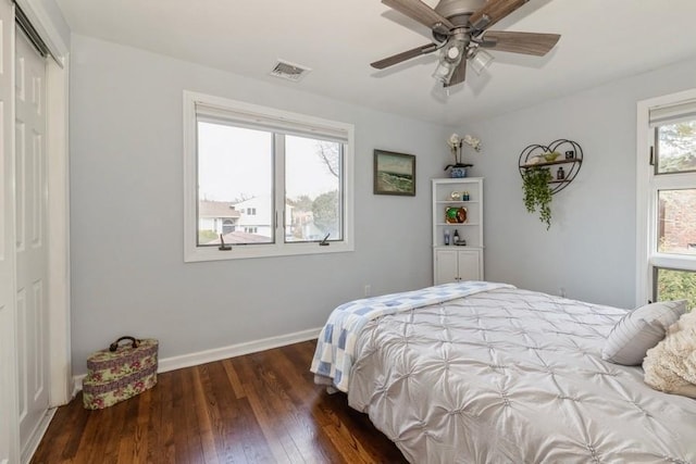 bedroom featuring hardwood / wood-style flooring, multiple windows, baseboards, and visible vents