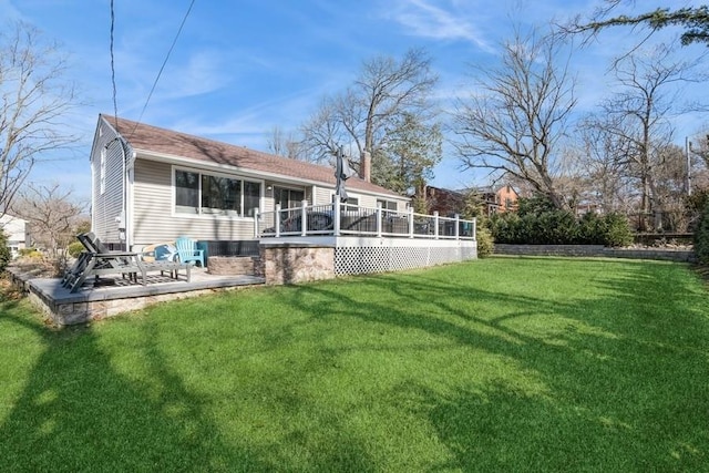 back of property with a patio, a lawn, a chimney, and a wooden deck