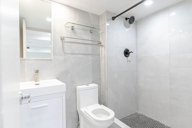 full bath with vanity, toilet, tile walls, and a shower stall