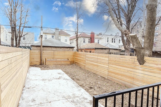 view of yard featuring a patio, a fenced backyard, and a residential view