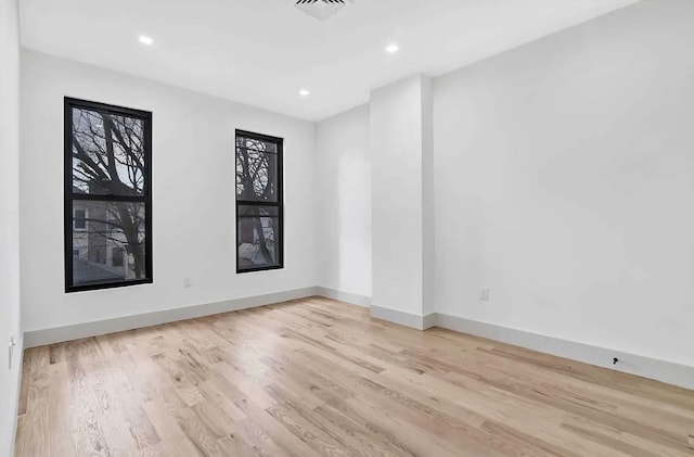 spare room featuring recessed lighting, wood finished floors, visible vents, and baseboards