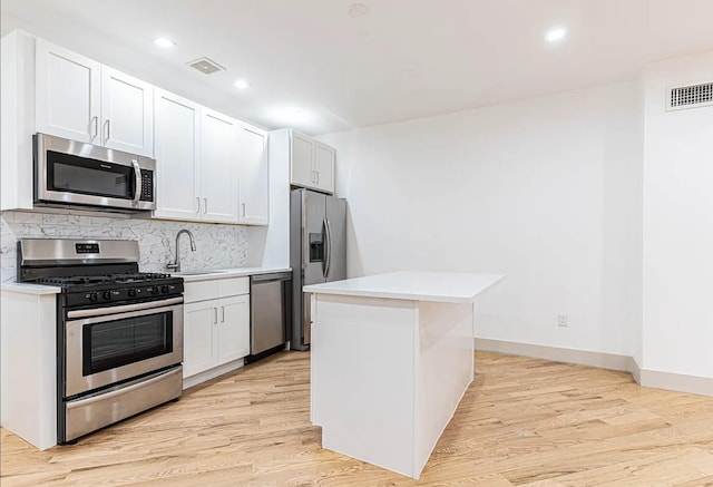 kitchen with tasteful backsplash, visible vents, light wood finished floors, appliances with stainless steel finishes, and a sink