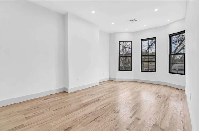 empty room featuring visible vents, recessed lighting, baseboards, and light wood-type flooring