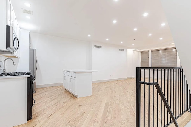 kitchen with white cabinetry, light wood-style floors, visible vents, and appliances with stainless steel finishes