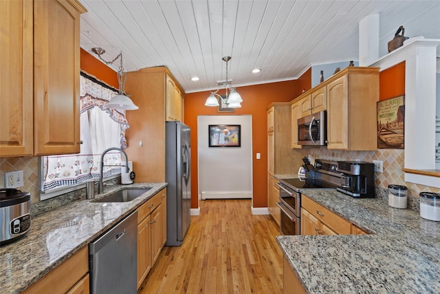 kitchen with light stone counters, a baseboard radiator, stainless steel appliances, and a sink