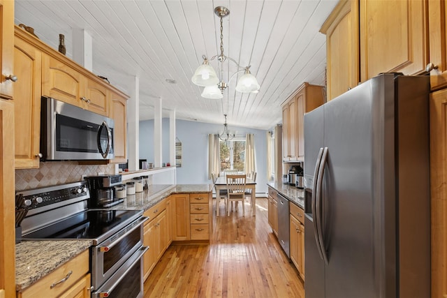 kitchen featuring light wood-style flooring, stainless steel appliances, pendant lighting, tasteful backsplash, and a chandelier