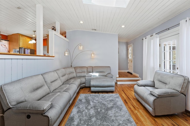 living area with recessed lighting, vaulted ceiling with skylight, wooden ceiling, and light wood finished floors