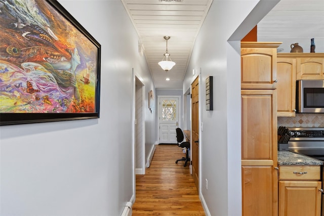 hall featuring baseboards and light wood-type flooring