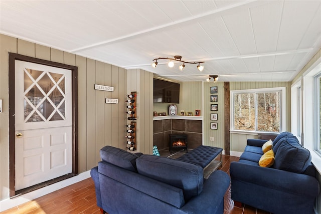 living area featuring a warm lit fireplace and wood finished floors