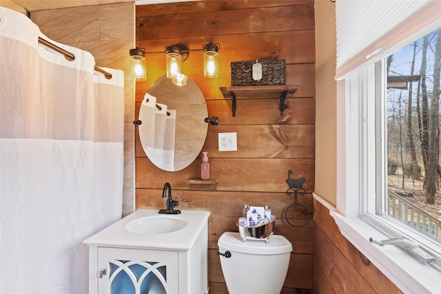 full bathroom with vanity, curtained shower, toilet, and wood walls