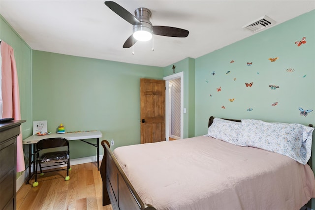 bedroom featuring baseboards, a ceiling fan, visible vents, and light wood-type flooring