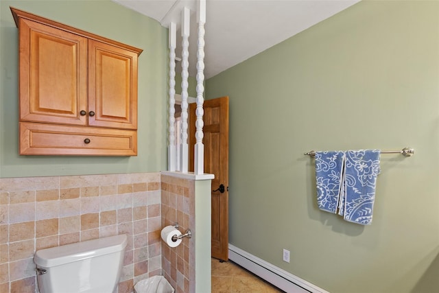 bathroom with a baseboard heating unit, tile walls, toilet, and tile patterned floors