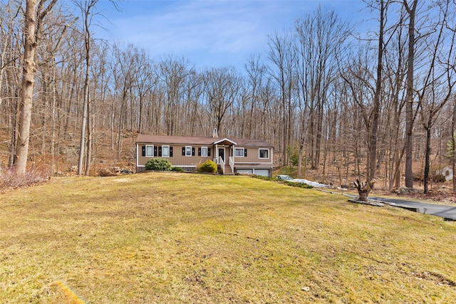 view of front of house with a forest view and a front yard