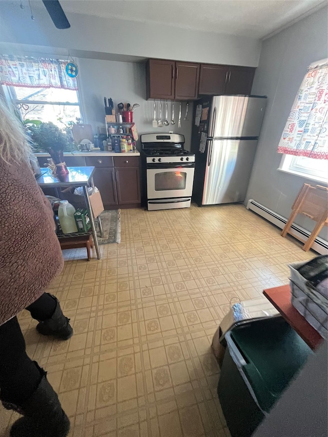 kitchen with dark brown cabinetry, baseboard heating, stainless steel appliances, and light countertops