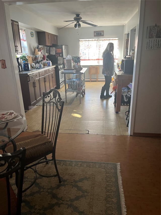 dining space featuring a baseboard heating unit, a wealth of natural light, and ceiling fan