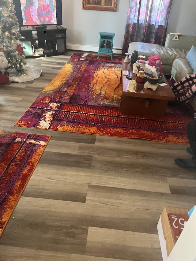 living room with a baseboard heating unit and wood finished floors