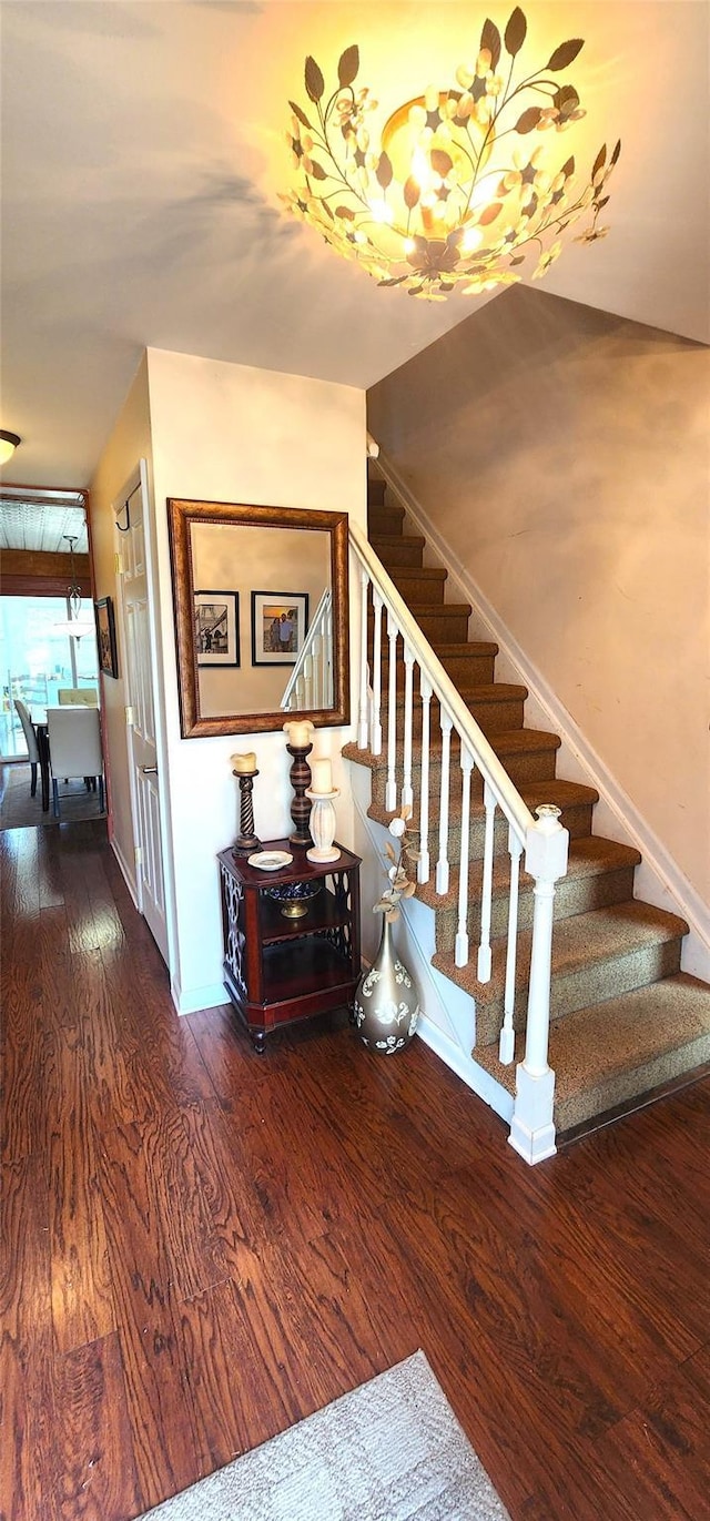 stairway with baseboards and wood finished floors