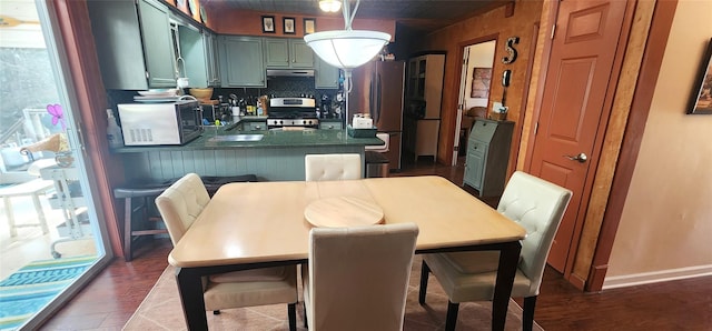 dining area featuring baseboards and dark wood finished floors