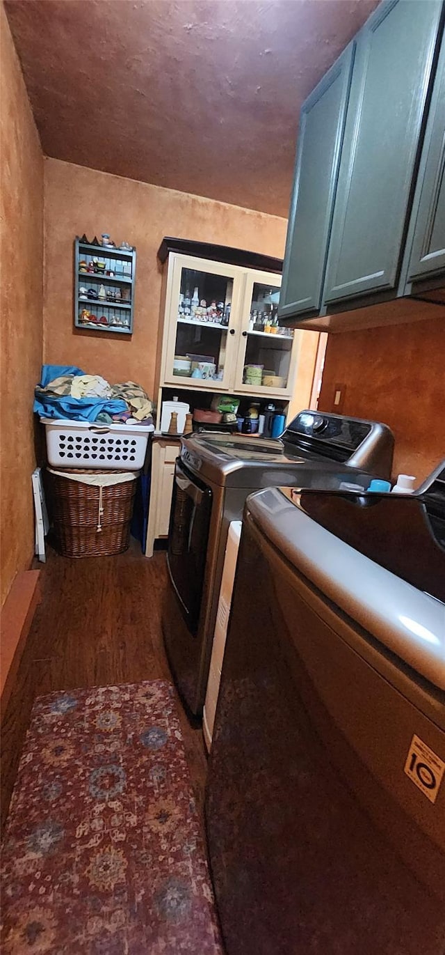 laundry area featuring cabinet space, dark wood finished floors, and separate washer and dryer