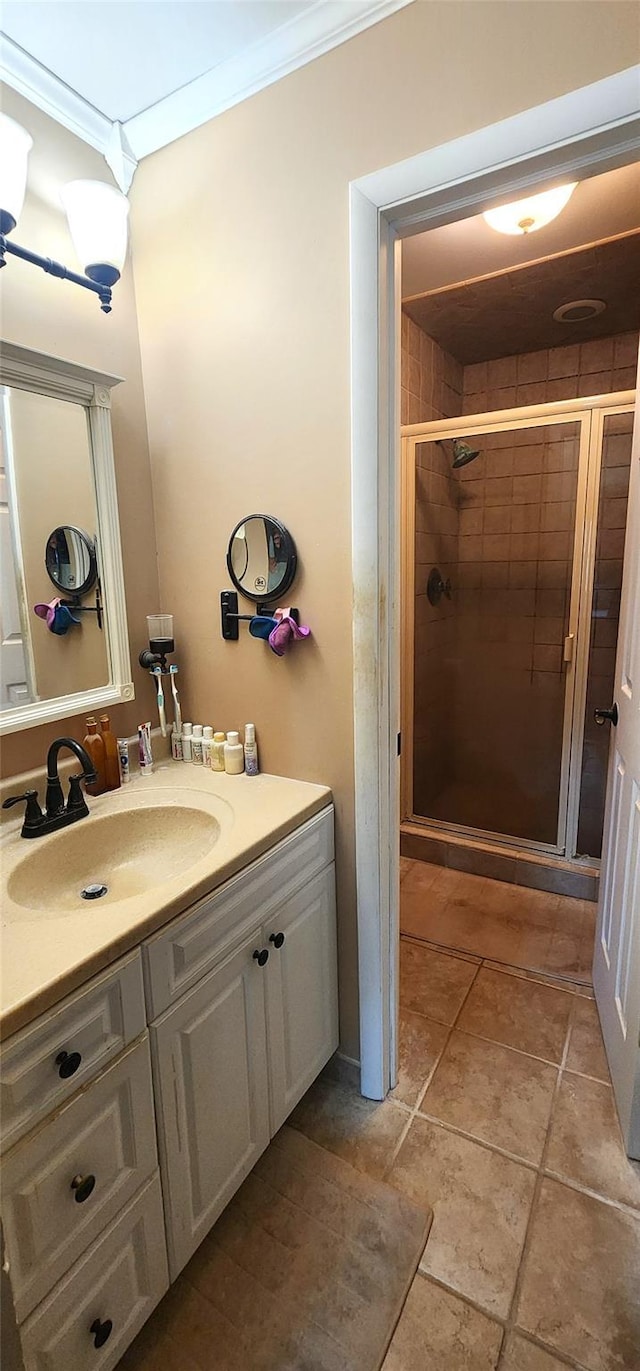 bathroom featuring tile patterned floors, vanity, ornamental molding, and a stall shower