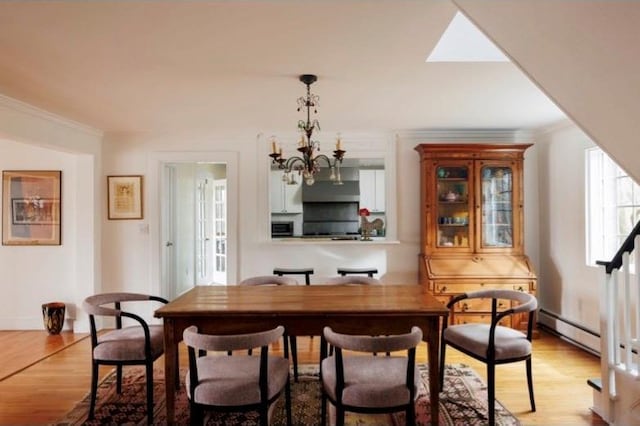26 Curry Ln, Hyde Park, NY 12538 - dining space with an inviting chandelier, baseboard heating, ornamental molding, baseboards, and light wood-type flooring