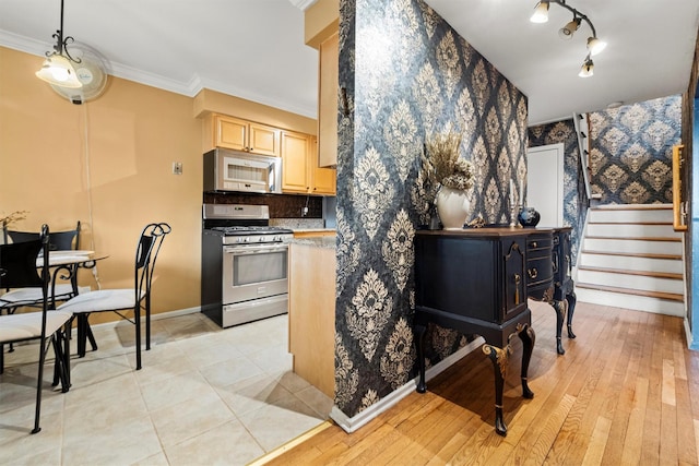 kitchen with ornamental molding, light brown cabinets, tasteful backsplash, gas range, and white microwave