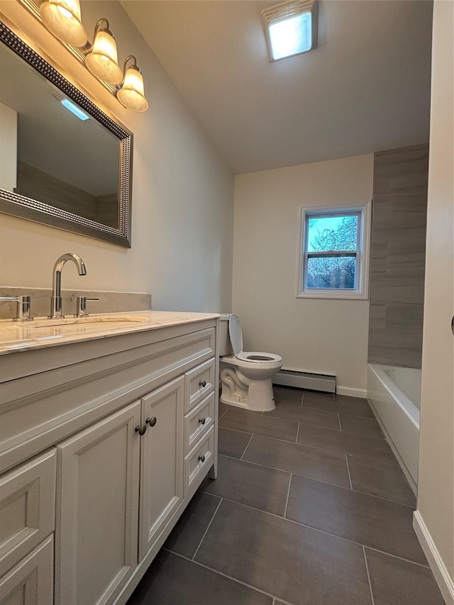 bathroom with vanity, baseboards, a baseboard radiator, a tub, and toilet