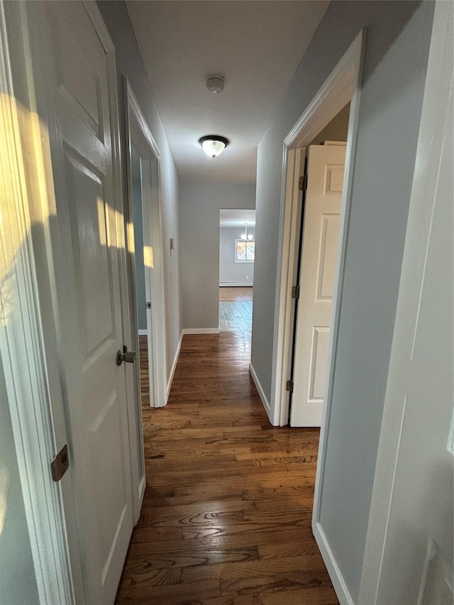 corridor with dark wood finished floors and baseboards