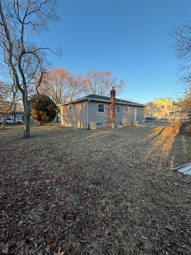 rear view of property featuring a chimney