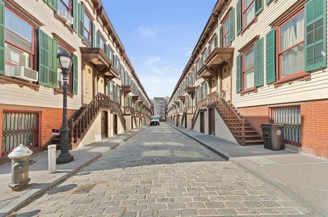 view of road with curbs, stairway, and a residential view