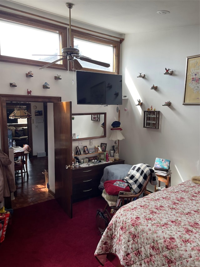 carpeted bedroom with multiple windows and a ceiling fan