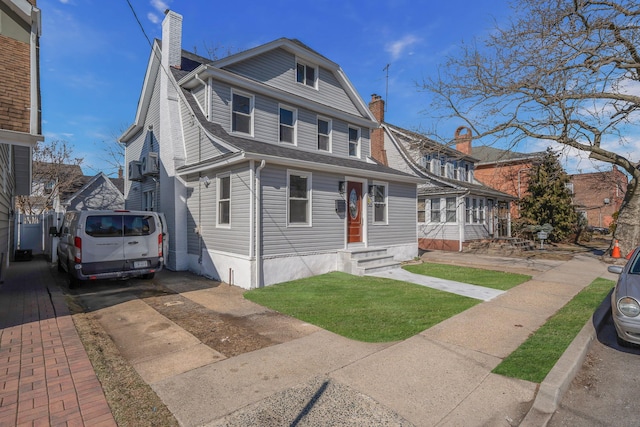 view of front of property with a shingled roof, a chimney, and entry steps