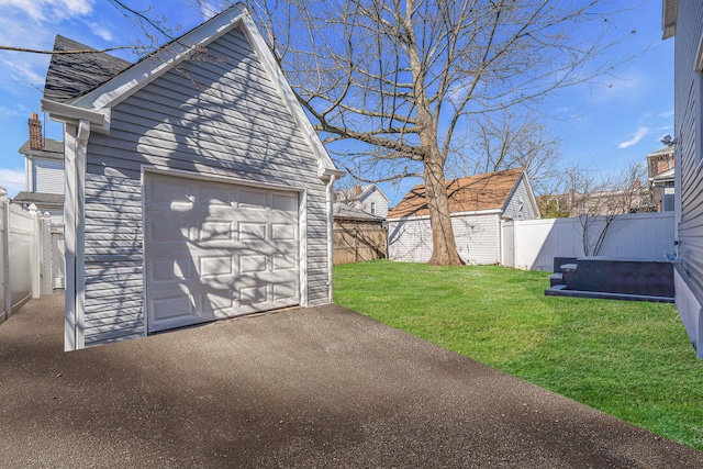 detached garage featuring driveway and fence