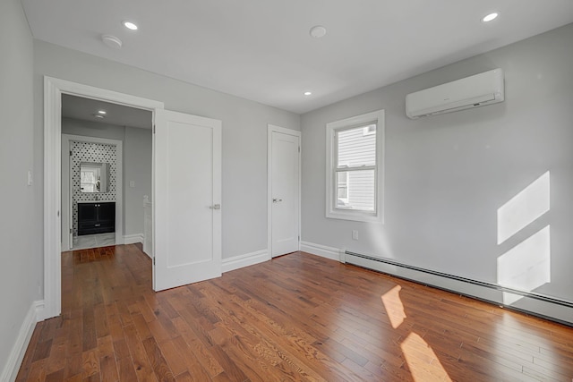 interior space featuring hardwood / wood-style floors, recessed lighting, a wall mounted air conditioner, and a baseboard radiator