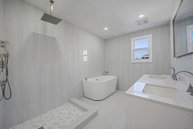 full bath featuring a sink, a freestanding tub, visible vents, and a tile shower