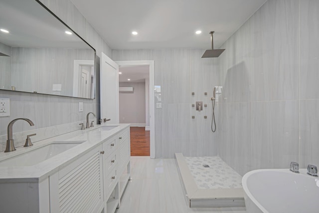 full bath with a freestanding tub, tiled shower, and a sink