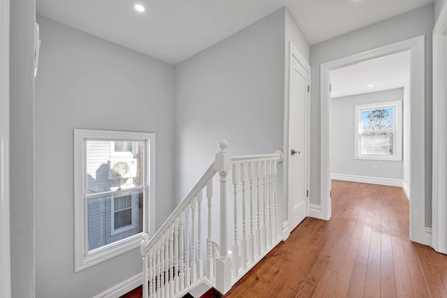 hall featuring an upstairs landing, recessed lighting, baseboards, and hardwood / wood-style floors